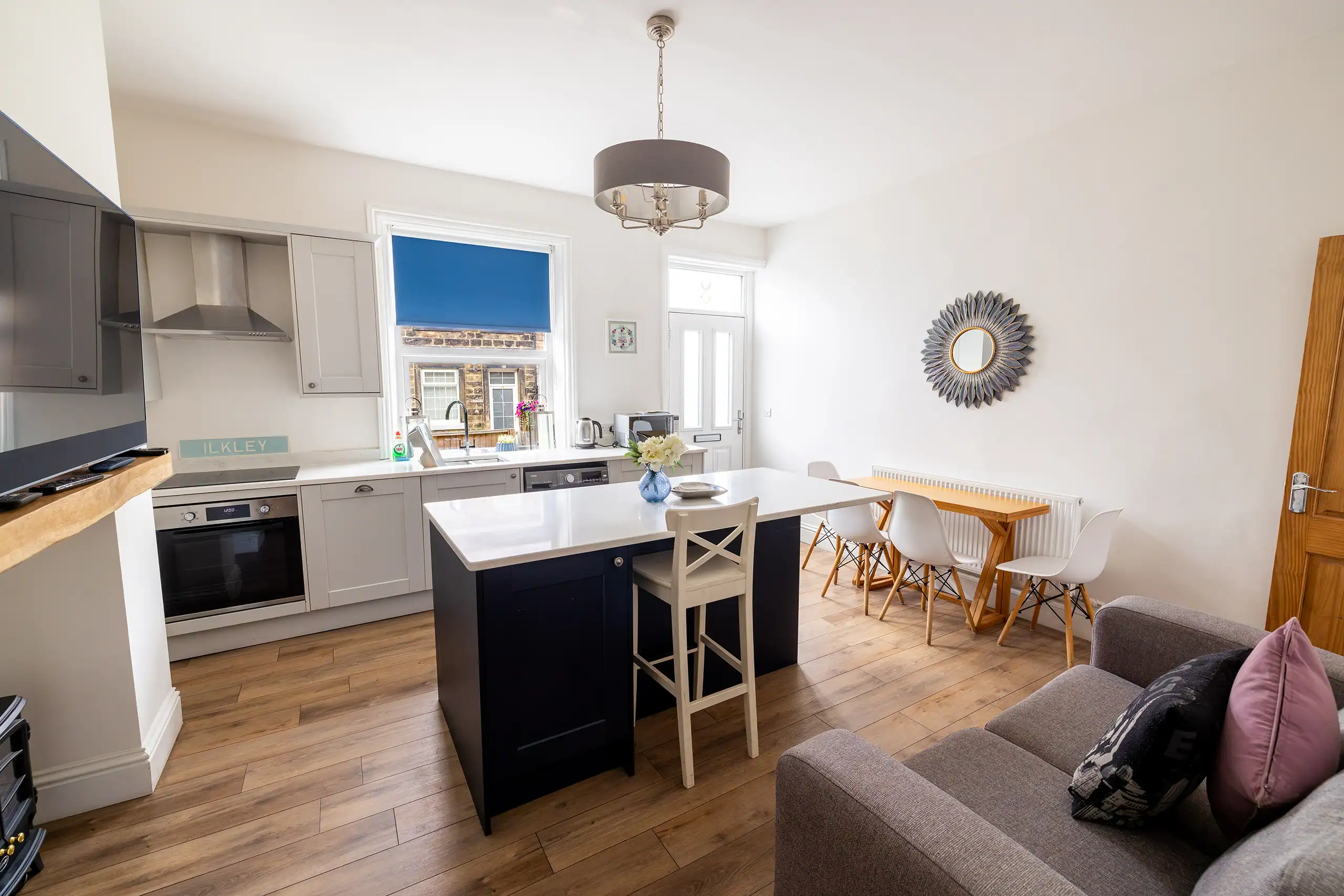 Bright kitchen and dining area with large windows at Dale Cottage